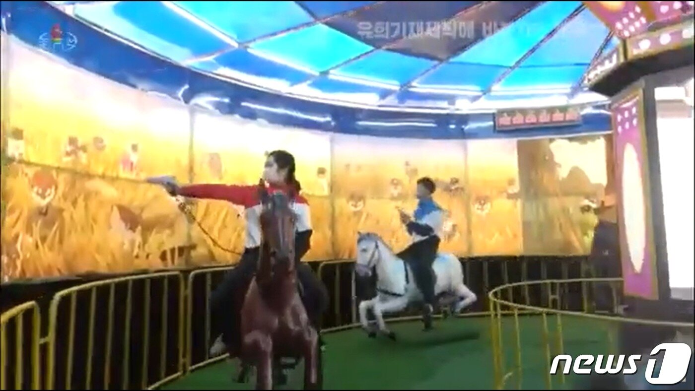 본문 이미지 - 북한 목란광명기술사에서 제작한 사격 유희기재(오락기)를 즐기는 주민들의 모습. ('조선중앙TV' 갈무리) ⓒ 뉴스1