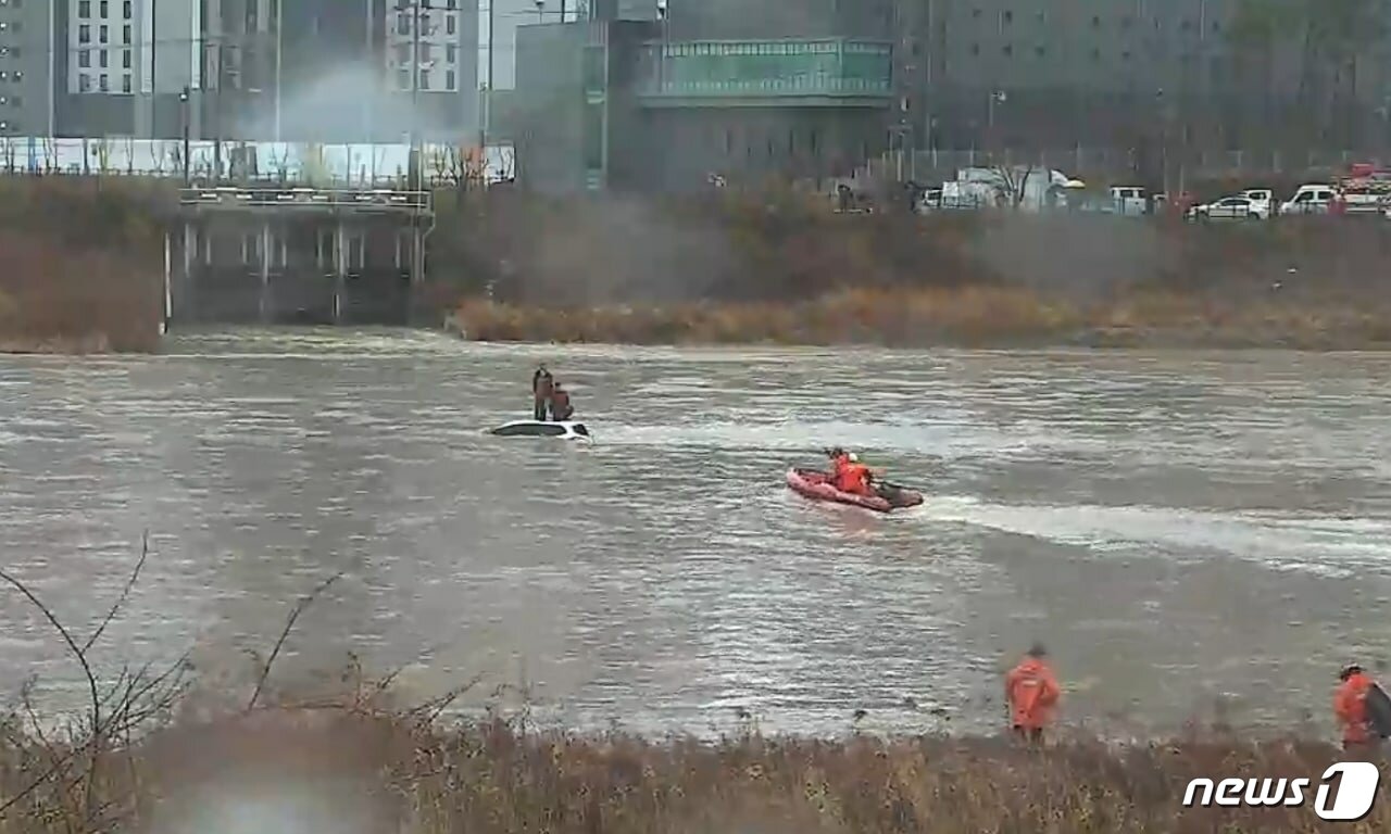 본문 이미지 - 구리 왕숙천 폭우로 떠내려가는 SUV 지붕 위 시민 2명을 구조하는 모습 (사진=경기도북부소방재난본부) ⓒ 뉴스1