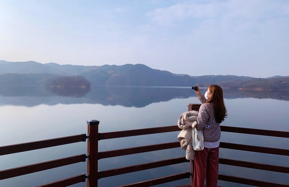 본문 이미지 - 마스크를 쓰고 호수 경치를 감상하고 있는 여행객의 모습ⓒ 뉴스1