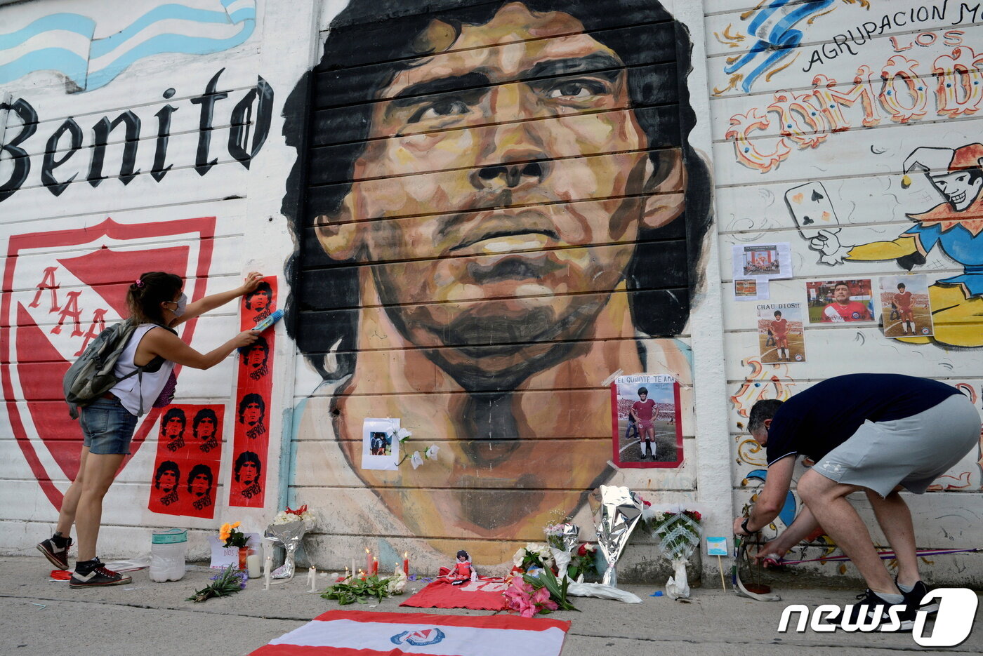 본문 이미지 - 부에노스 아이레스의 한 축구장 벽화 앞에서 주민들이 마라도나의 죽음을 추모하고 있다. ⓒ 로이터=뉴스1