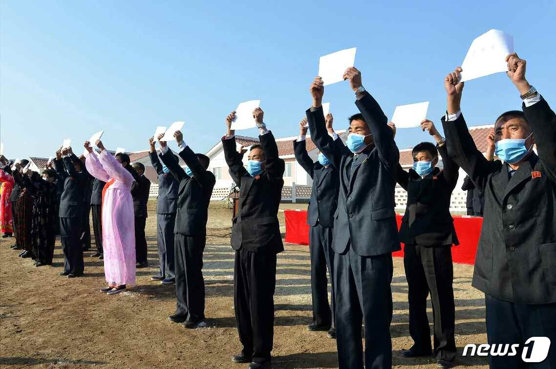 본문 이미지 - (평양 노동신문=뉴스1) = 수해복구를 마치고 살림집을 받은 주민들이 입사증을 들고 서 있다. [국내에서만 사용가능. 재배포 금지. DB 금지. For Use Only in the Republic of Korea. Redistribution Prohibited] rodongphoto@news1.kr