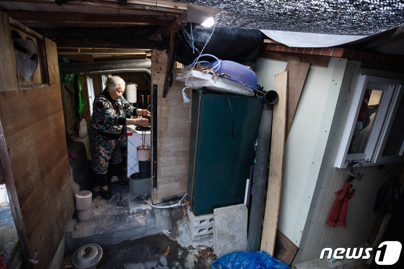 본문 이미지 - 30일 서울 서초구 남태령 전원마을에서 한 어르신이 연탄보일러의 연탄을 갈고 있다. 신종 코로나바이러스 감염증(코로나19) 확산 여파로 인한 경제적 타격과 감염 우려에 따른 봉사 신청이 줄며 연탄 후원이 크게 줄었다. 2020.11.30/뉴스1 ⓒ News1 유승관 기자