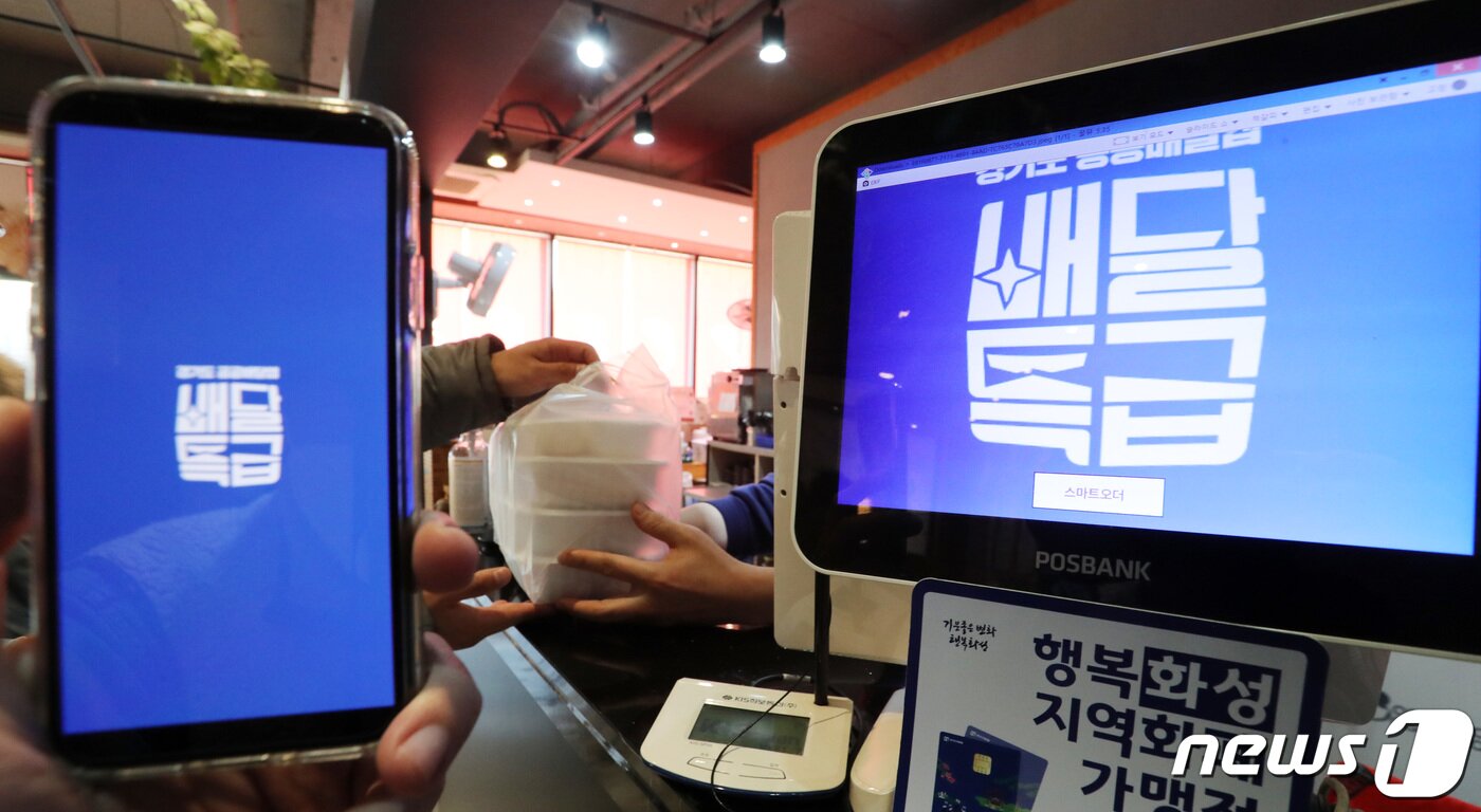 본문 이미지 - 경기도의 공공 배달 앱인 '배달특급'의 시범 서비스가 시작된 1일 오후 경기도 화성시내 한 음식점에서 점주가 앱을 통해 주문된 음식을 전달하고 있다. 배달특급은 이날부터 화성·오산·파주 3곳에서 시범 서비스를 시작했으며 내년 하반기까지 27개 시·군으로 사업 대상지를 확대할 계획이다. 2020.12.1/뉴스1 ⓒ News1 조태형 기자