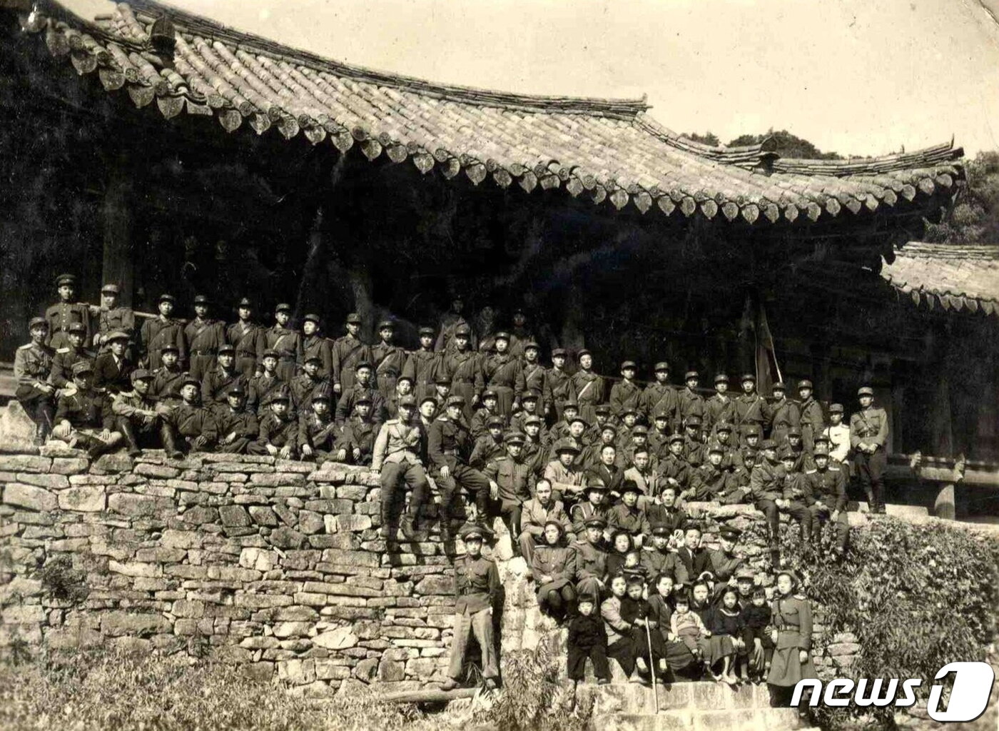 본문 이미지 - 1949년 10월 김일성 수상이 인민군 대원들과 함께 천주사를 방문해 천주루 앞에서 기념촬영하고 있다. 4번째 줄 가운데에 김일성 수상이 앉아 있고, 맨 앞줄에 어린 김정일(왼쪽에서 3번째)의 모습이 보인다. (미디어한국학 제공) 2020.12.12.ⓒ 뉴스1