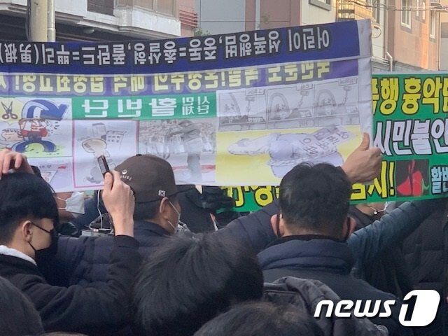 본문 이미지 - 조두순이 12일 오전 8시55분께 거주지인 안산 모처에 도착하기 직전 한 시위대가 플랫카드를 펴보이며 분통을 터뜨리고 있다. ⓒ 뉴스1 조정훈 기자