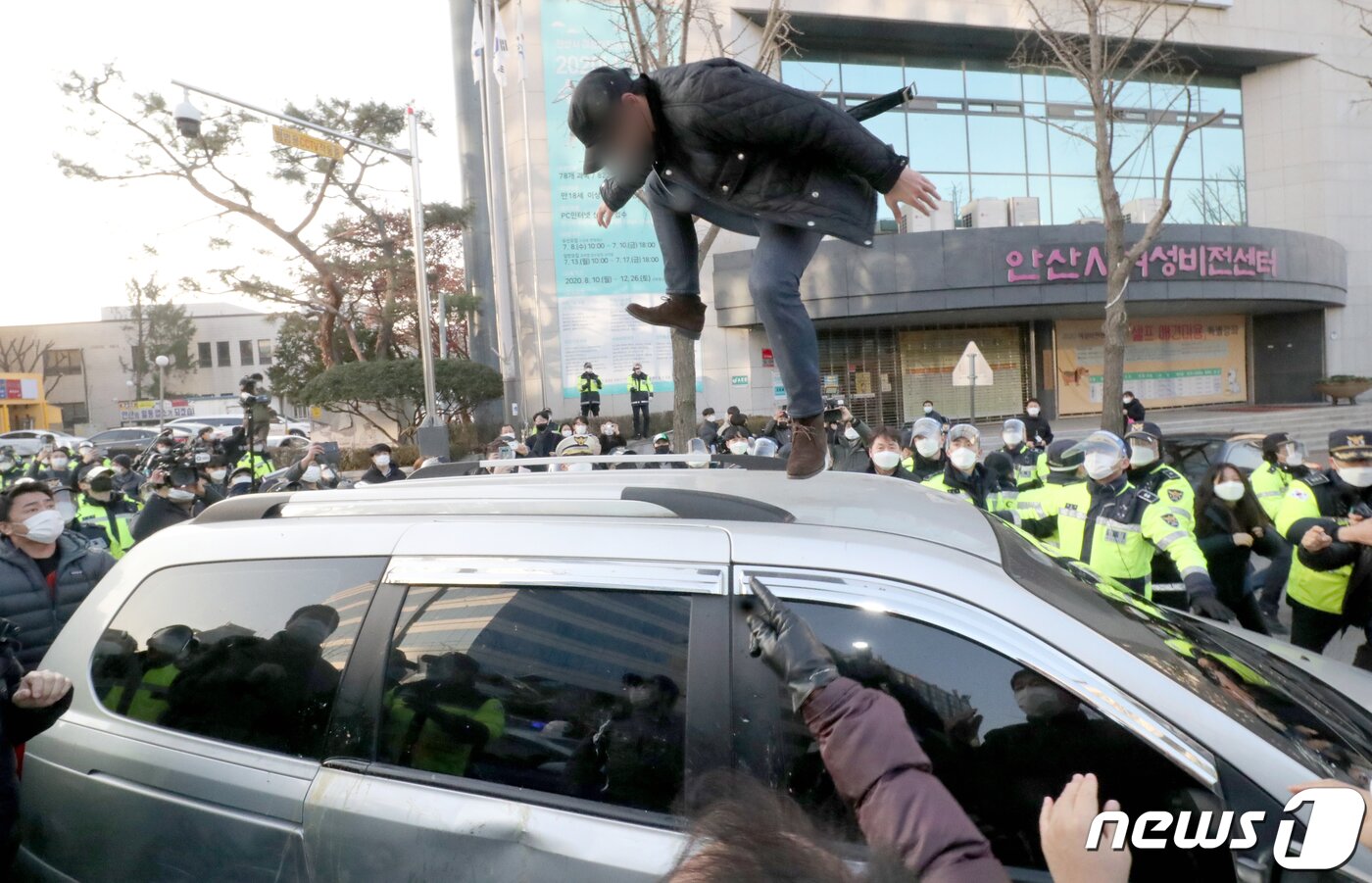 본문 이미지 - 12일 오전 안산시내에서 한 유튜버가 거주지로 향하는 조두순이 탑승한 차량을 공격하고 있다. 2020.12.12/뉴스1 ⓒ News1 조태형 기자