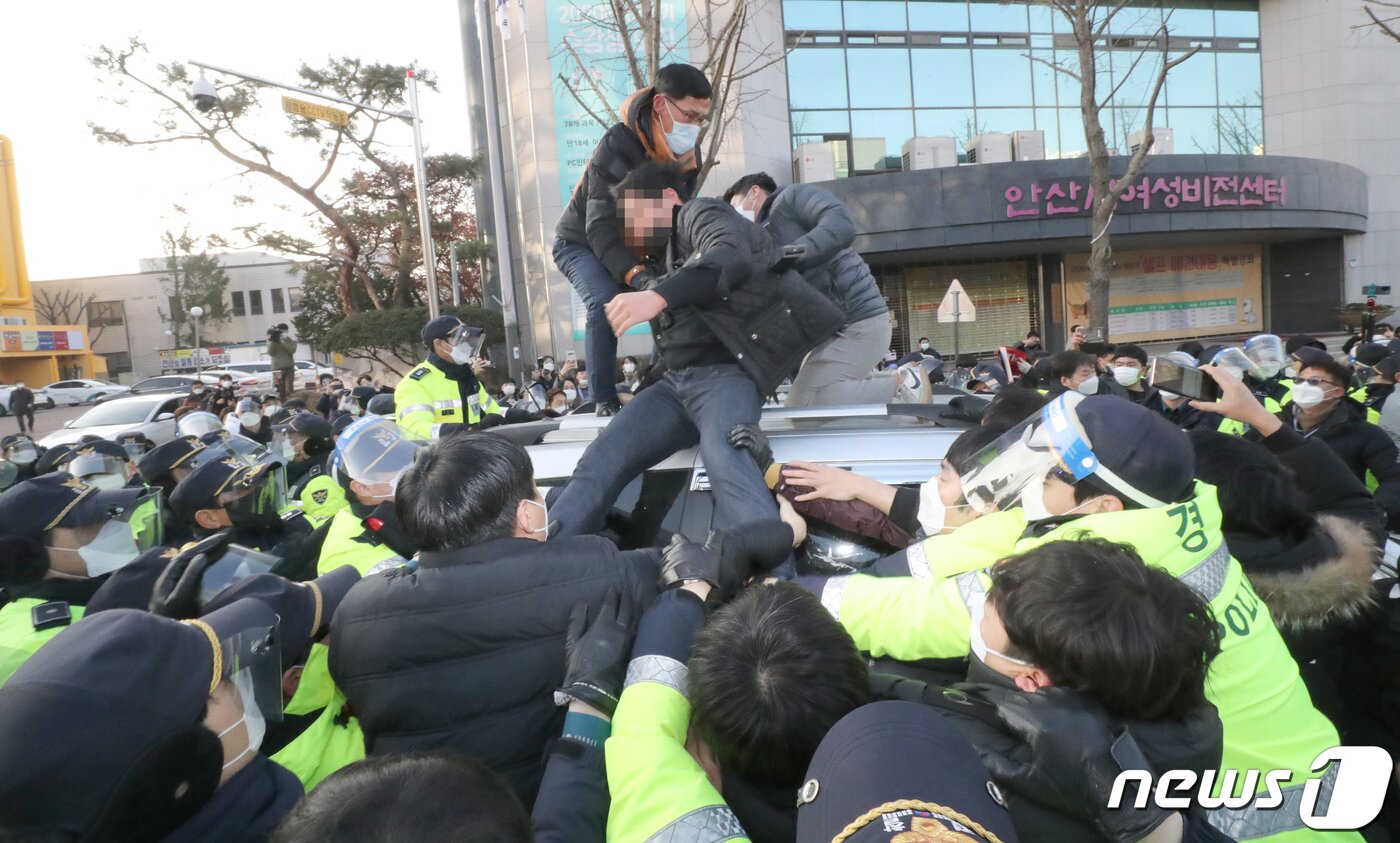 본문 이미지 - 12일 오전 안산시내에서 일부 시민들이 거주지로 향하는 조두순이 탑승한 차량을 막아서고 있다. 2020.12.12/뉴스1 ⓒ News1 조태형 기자