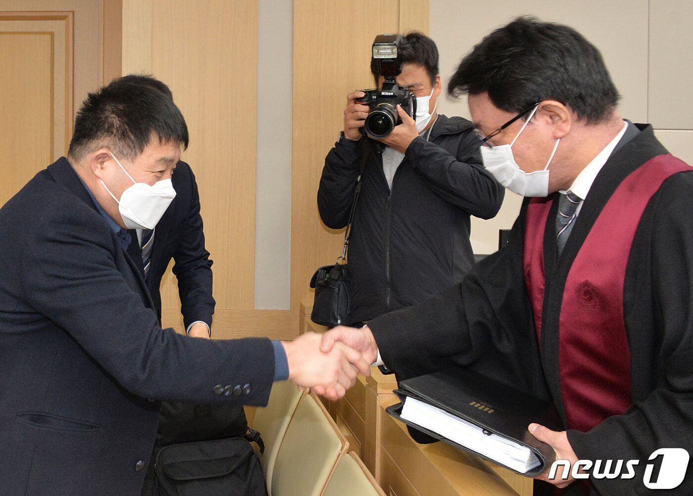 본문 이미지 - 17일 오후 경기도 수원시 영통구 수원지방법원에서 열린 이춘재 연쇄살인 8차 사건 재심 선고공판에서 재심 청구인 윤성여 씨가 무죄를 선고받고 검사와 악수하고 있다. 2020.12.17 사진공동취재단 ⓒ News1 사진공동취재단