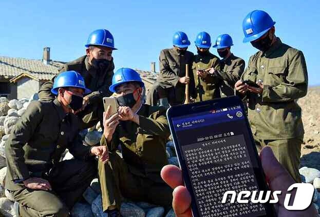 본문 이미지 - &#40;평양 노동신문=뉴스1&#41; =   수해 복구에 투입된 인민군들이 휴대전화로 위문편지를 읽고 있는 모습. [국내에서만 사용가능. 재배포 금지. DB 금지. For Use Only in the Republic of Korea. Redistribution Prohibited] rodongphoto@news1.kr