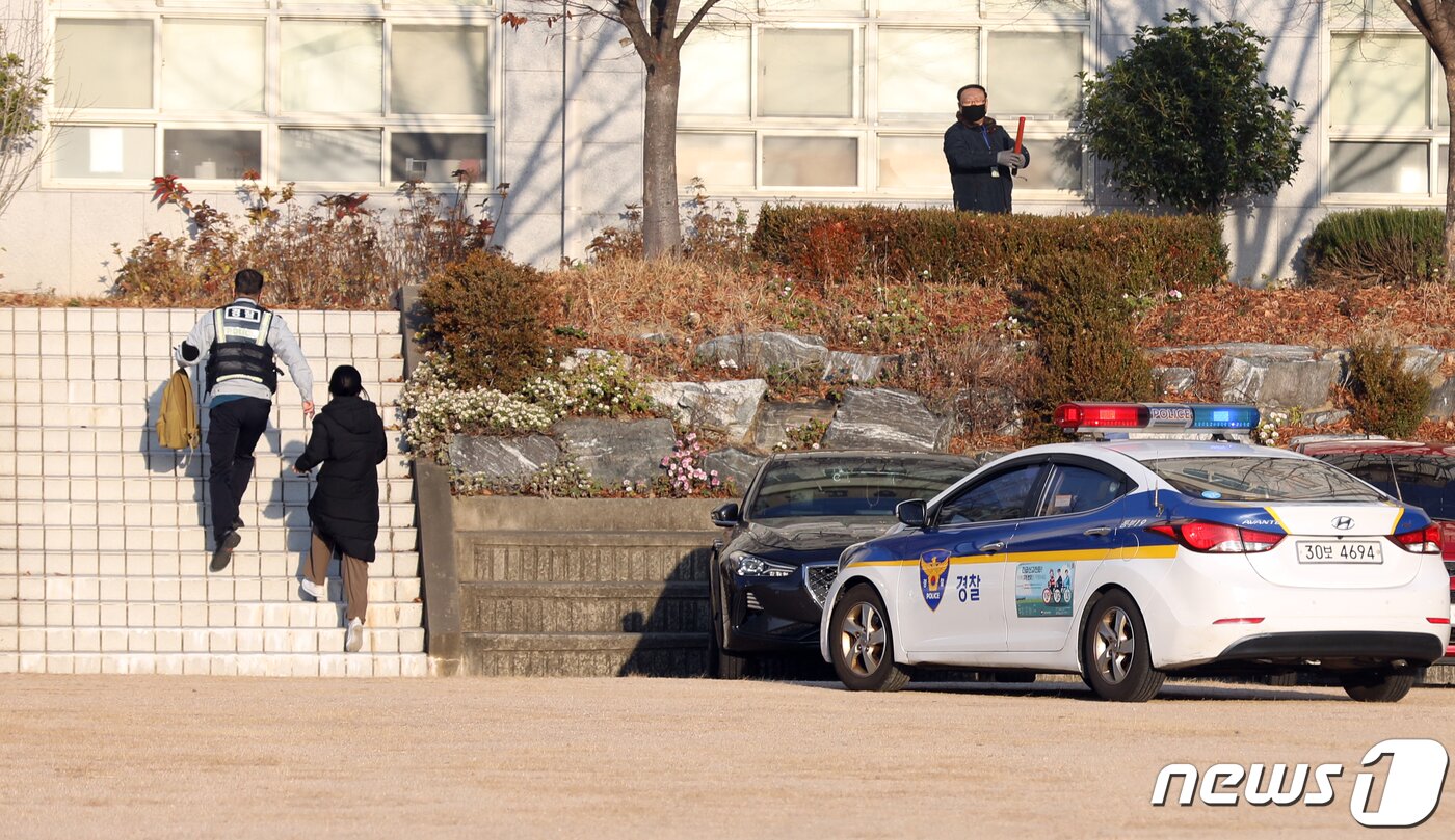 본문 이미지 - 2021학년도 대학수학능력시험이 실시된 3일 오전 부산 동구 경남여자여고에 마련된 시험장으로 경찰차를 타고 들어온 수험생이 경찰관과 함께 수험장으로 향하고 있다. 2020.12.3/뉴스1 ⓒ News1 여주연 기자