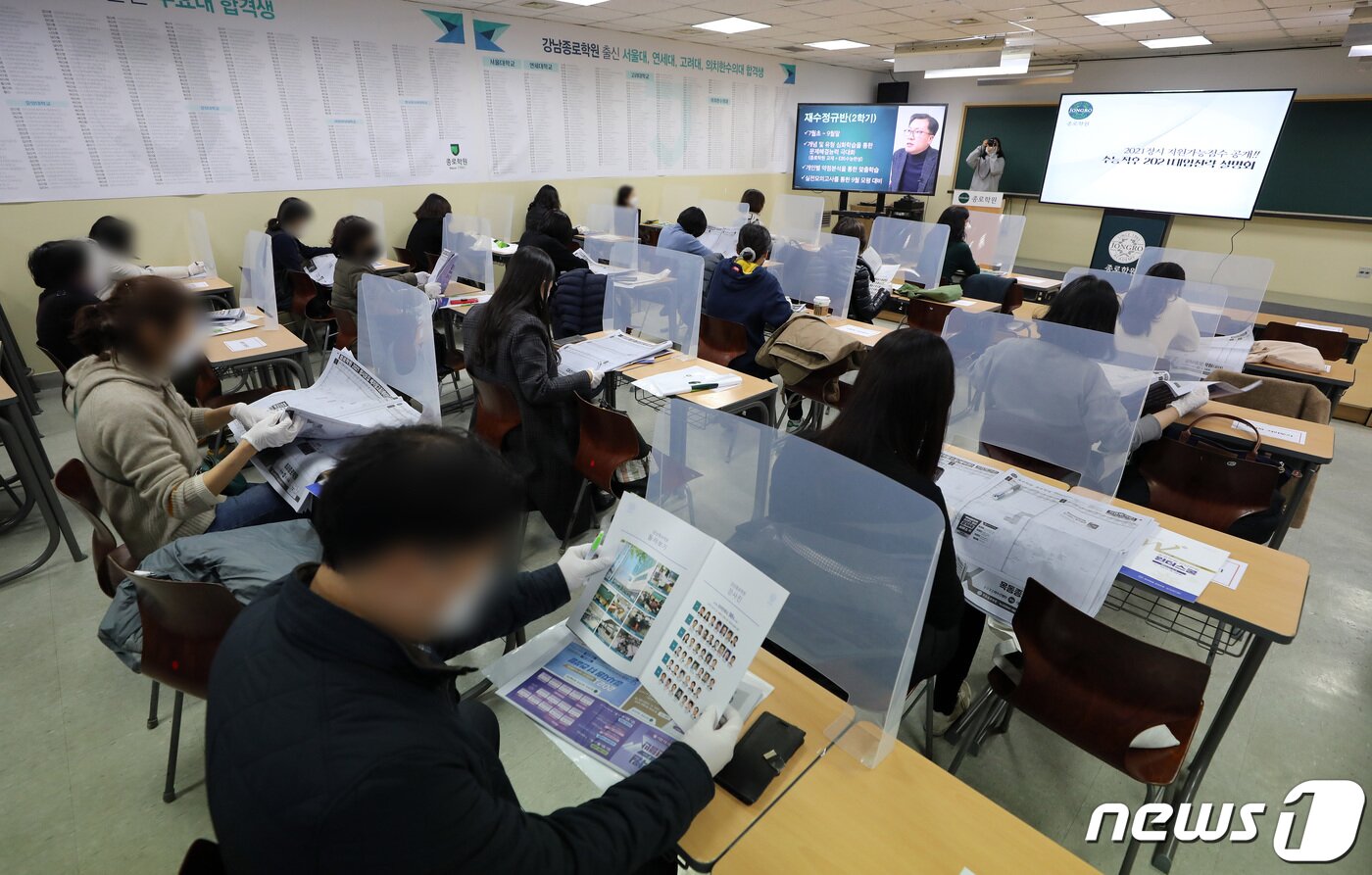 본문 이미지 - 4일 오후 서울 강남구 종로학원에서 열린 2021학년도 대학수학능력시험 합격예측점수 설명회를 찾은 학무보들이 배치참고표를 살펴보고 있다. 이날 설명회는 신종 코로나바이러스 감염증(코로나19) 사회적 거리두기 방역지침에 따라 최소한의 제한된 인원만 참석한 채 온라인으로 생중계 했다. 2020.12.4/뉴스1 ⓒ News1 이재명 기자