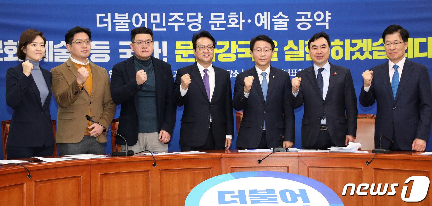 본문 이미지 - 조정식 더불어민주당 정책위의장이 12일 오전 서울 여의도 국회에서 열린 문화·예술 공약 발표 기자회견에서 참석자들과 함께 기념촬영을 하고 있다. 왼쪽부터 고민정 전 청와대 대변인, 김동원 태원엔터테인먼트 부사장, 양우석 감독, 안민석 의원, 조정식 정책위의장, 윤관석 정책위 수석부의장, 신경민 의원. 2020.2.12/뉴스1 ⓒ News1 박세연 기자