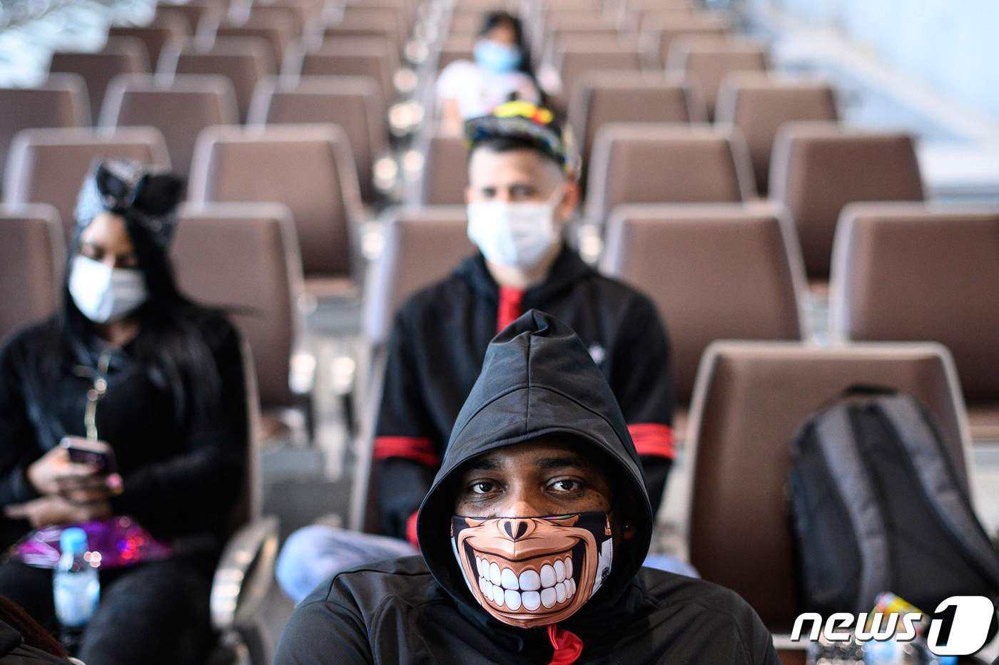 본문 이미지 - 5일 월드드림 크루즈선 승객들이 마스크를 쓴 채 앉아 있다. ⓒ AFP=뉴스1