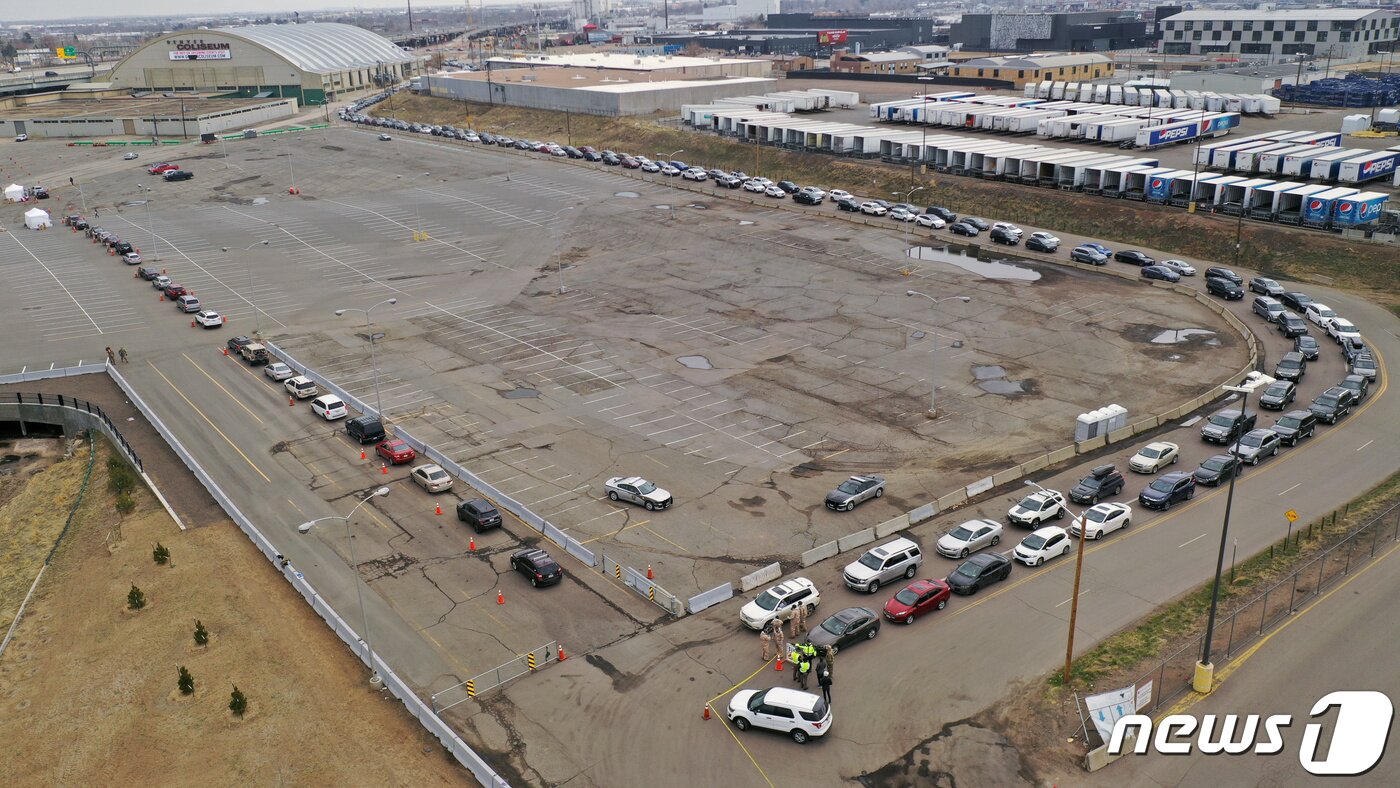 본문 이미지 - 14일&#40;현지시간&#41; 미국 콜로라도주 덴버의 덴버콜리시엄 주차장에서 차량들이 &#39;드라이브 스루&#39; 방식의 코로나19 검사를 받기 위해 장사진을 치고 있다. ⓒ 로이터=뉴스1 ⓒ News1 송원영 기자