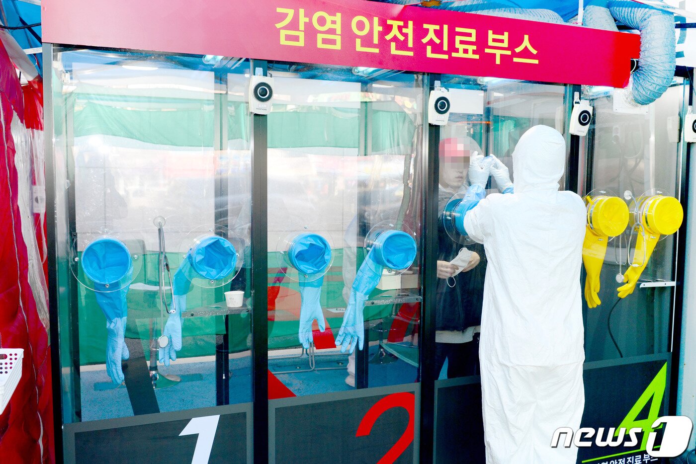 본문 이미지 - 에이치플러스 양지병원에 설치된 '도보 이동형(이하 워킹스루)' 선별진료소에서 의료진이 의심환자 검체를 채취하고 있다.ⓒ 뉴스1