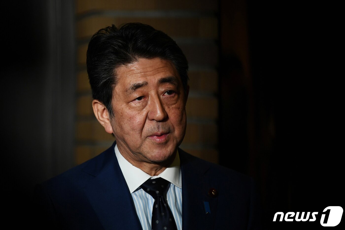 본문 이미지 - 아베 신조 일본 총리가 24일 도쿄 총리 관저 앞에서 토마스 바흐 국제올림픽위원회&#40;IOC&#41; 위원장과 통화한 뒤 취재진의 질의에 답하고 있다. ⓒ 로이터=뉴스1 ⓒ News1 신웅수 기자