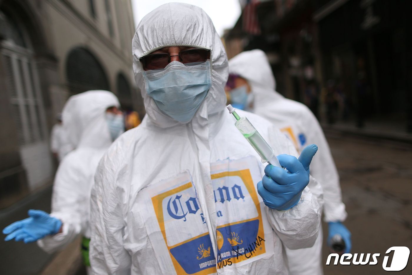 본문 이미지 - 미국 루이지애나주의 한 지역행사에 참여한 주민이 방호복과 마스크, 장갑을 착용하고 있다. ⓒ AFP=뉴스1