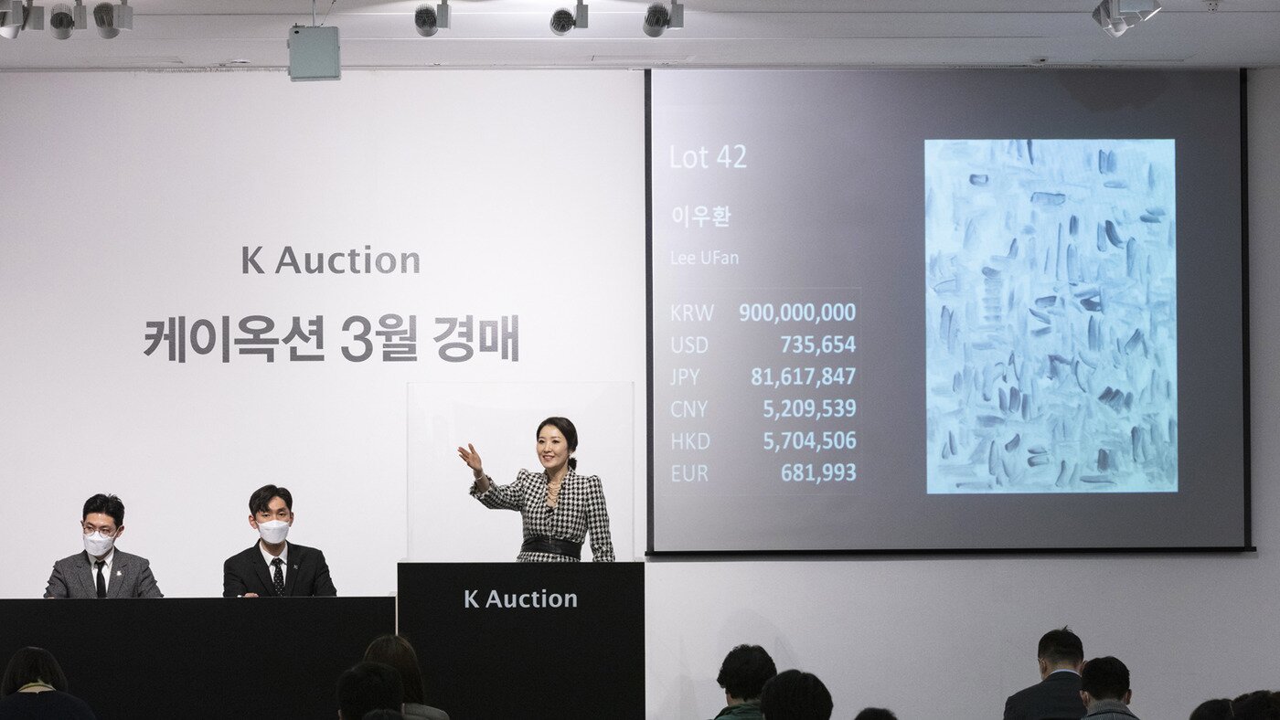 본문 이미지 - 손이천 케이옥션 경매사가 코로나19 예방을 위해 투명 아크릴 박스에 싸여 경매를 진행하는 모습. 케이옥션 3월 경매에서 이우환의 '바람과 함께'가 이날 최고가인 9억원에 낙찰됐다.(케이옥션 제공)ⓒ 뉴스1