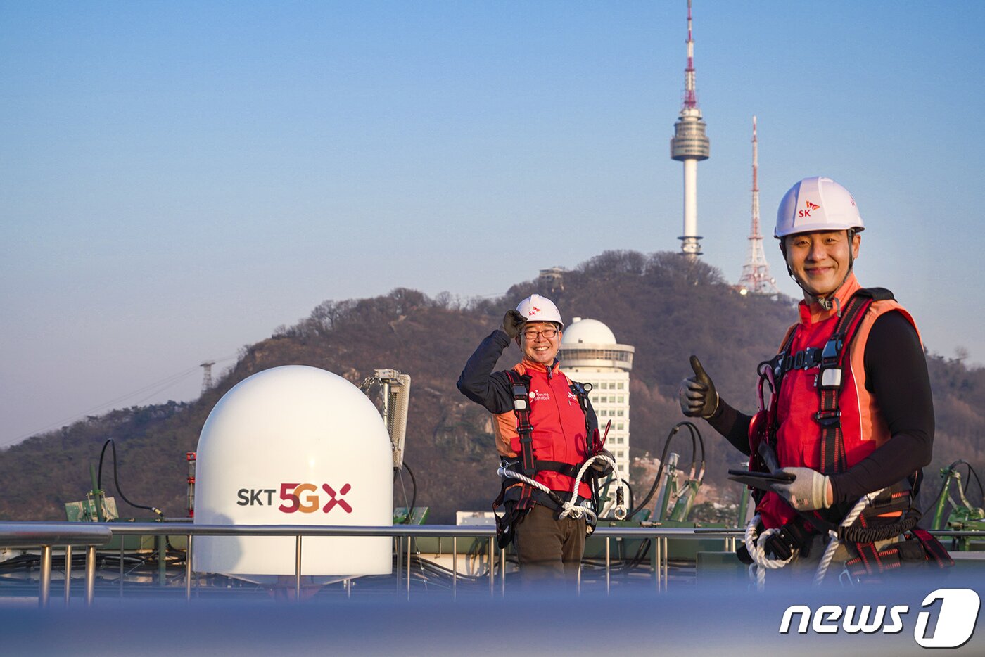 본문 이미지 - SK텔레콤 홍보모델들이 서울에 위치한 한 빌딩 위에서 5G 기지국을 점검하며 5G 상용화 1주년을 기념해 포즈를 취하고 있다. (SK텔레콤 제공)2020.3.29/뉴스1
