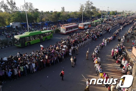 코로나19 확산으로 국가봉쇄령이 내려진 인도 뉴델리의 버스 터미널에 고향으로 돌아가려는 수십만명의 근로자들이 아수라장을 이루고 있다. © AFP=뉴스1 