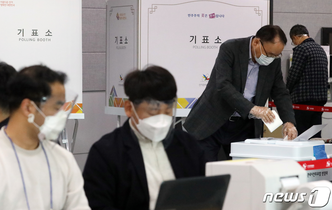 (부산=뉴스1) 여주연 기자 = 제21대 국회의원 선거 사전투표일인 10일 오후 부산 연제구청 2층 대강당을 찾은 유권자들이 투표를 하고 있다. 이날 투표사무원들은 코로나19 확산 …