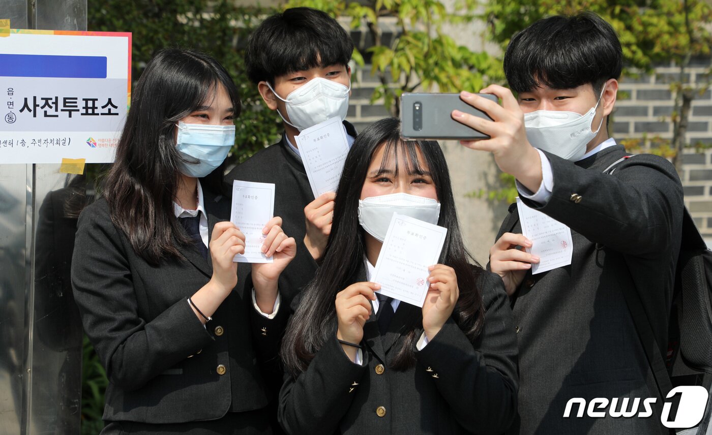 본문 이미지 - 제21대 국회의원 선거 사전 투표 첫날인 10일 오후 경기도 수원시 팔달구 행궁동 행정복지센터에 마련된 사전투표소에서 첫 투표를 마친 삼일공업고등학교 3학년인 만 18세 학생유권자들이 투표확인증을 들고 인증샷을 남기고 있다. 2020.4.10/뉴스1 ⓒ News1 조태형 기자