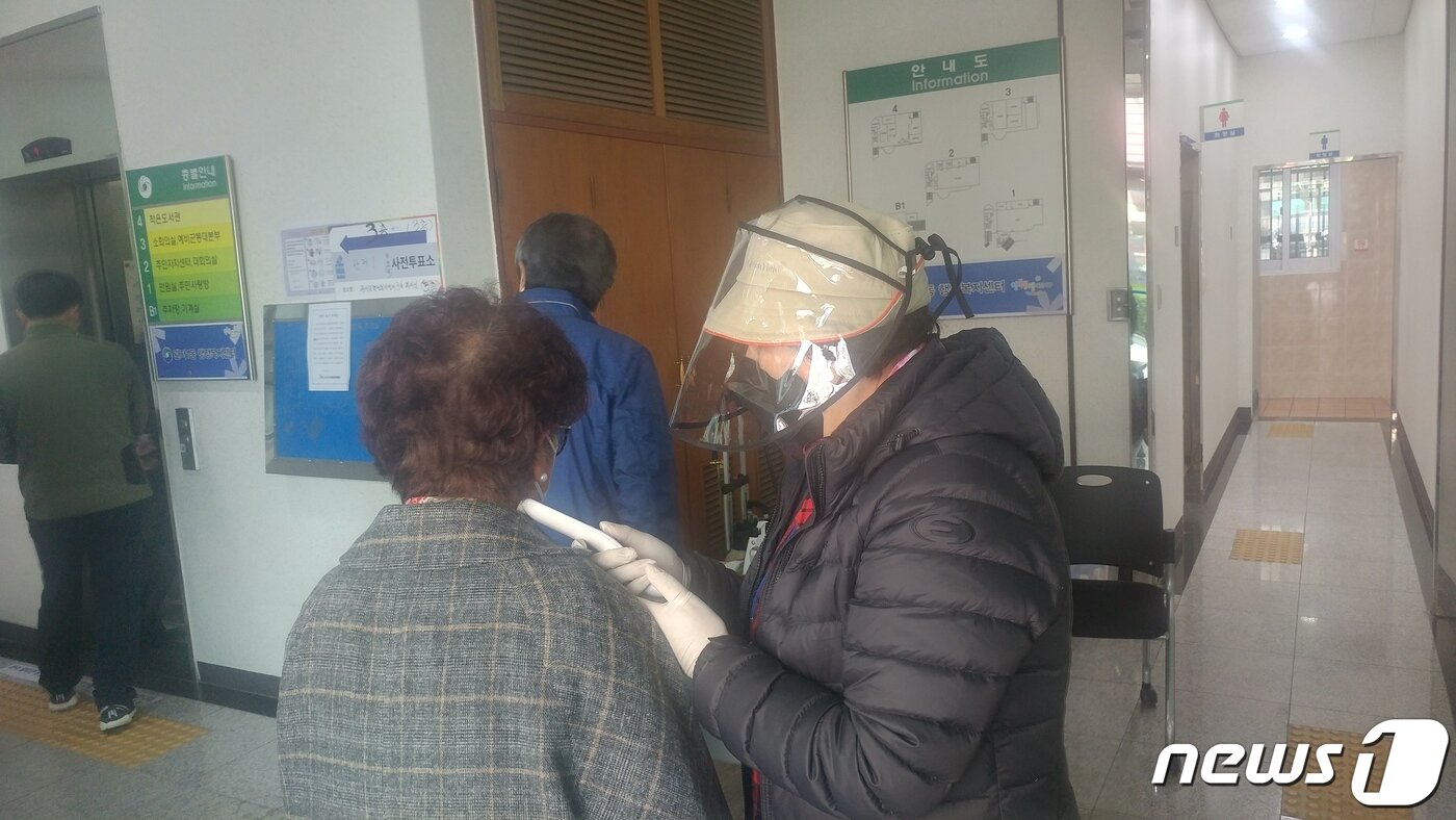 본문 이미지 - 대전 서구 관저동 행정복지센터에 마련된 사전투표소에서 선거사무원이 유권자의 체온을 측정하고 있다. ⓒ 뉴스1