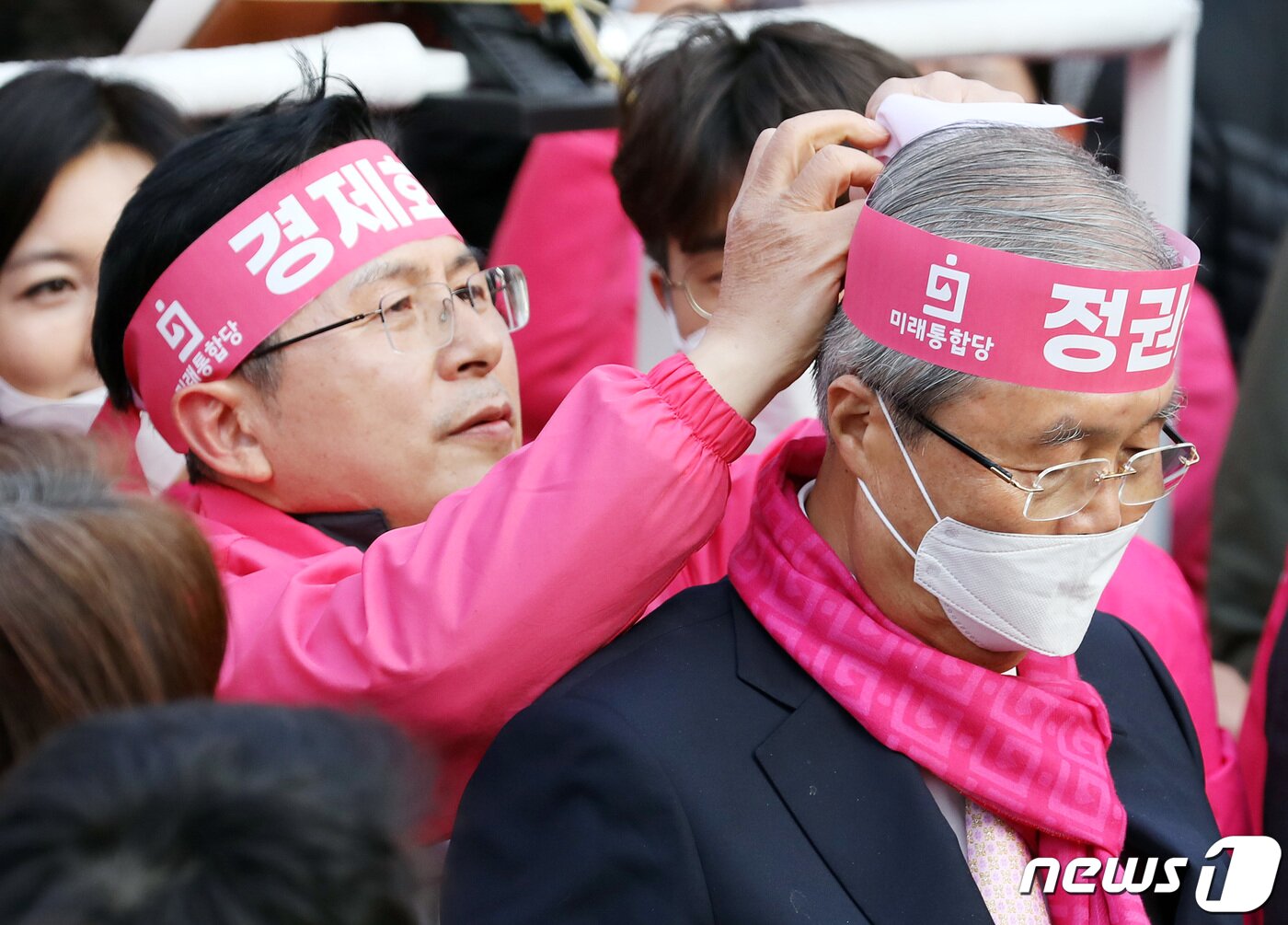 본문 이미지 - 황교안 미래통합당 종로구 후보가 11일 오후 서울 종로구 대학로 일대에서 열린 선거유세에서 김종인 총괄선대위원장에게 '정권심판'이 적힌 머리띠를 묶어주고 있다. 2020.4.11/뉴스1 ⓒ News1 이재명 기자