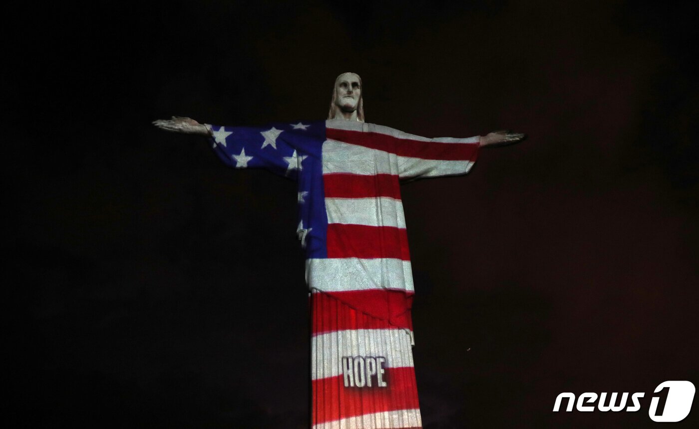 본문 이미지 - 브라질 리우데자네이루 예수상에 나타난 미국 성조기. ⓒ 로이터=뉴스1