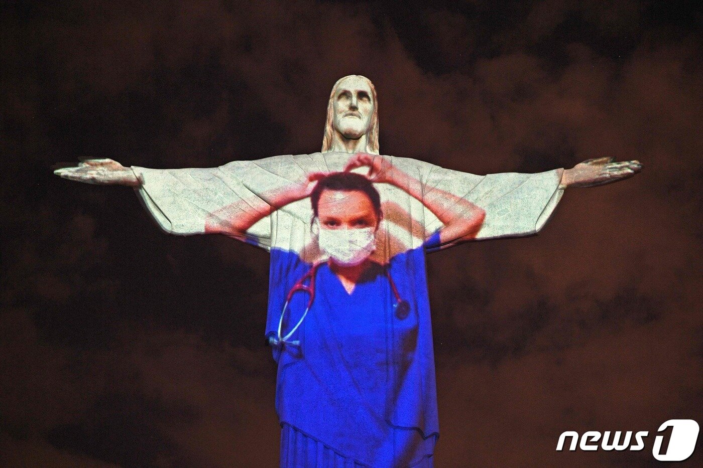 본문 이미지 - 브라질 리우데자네이루 예수상에 나타난 의료진의 모습. ⓒ AFP=뉴스1
