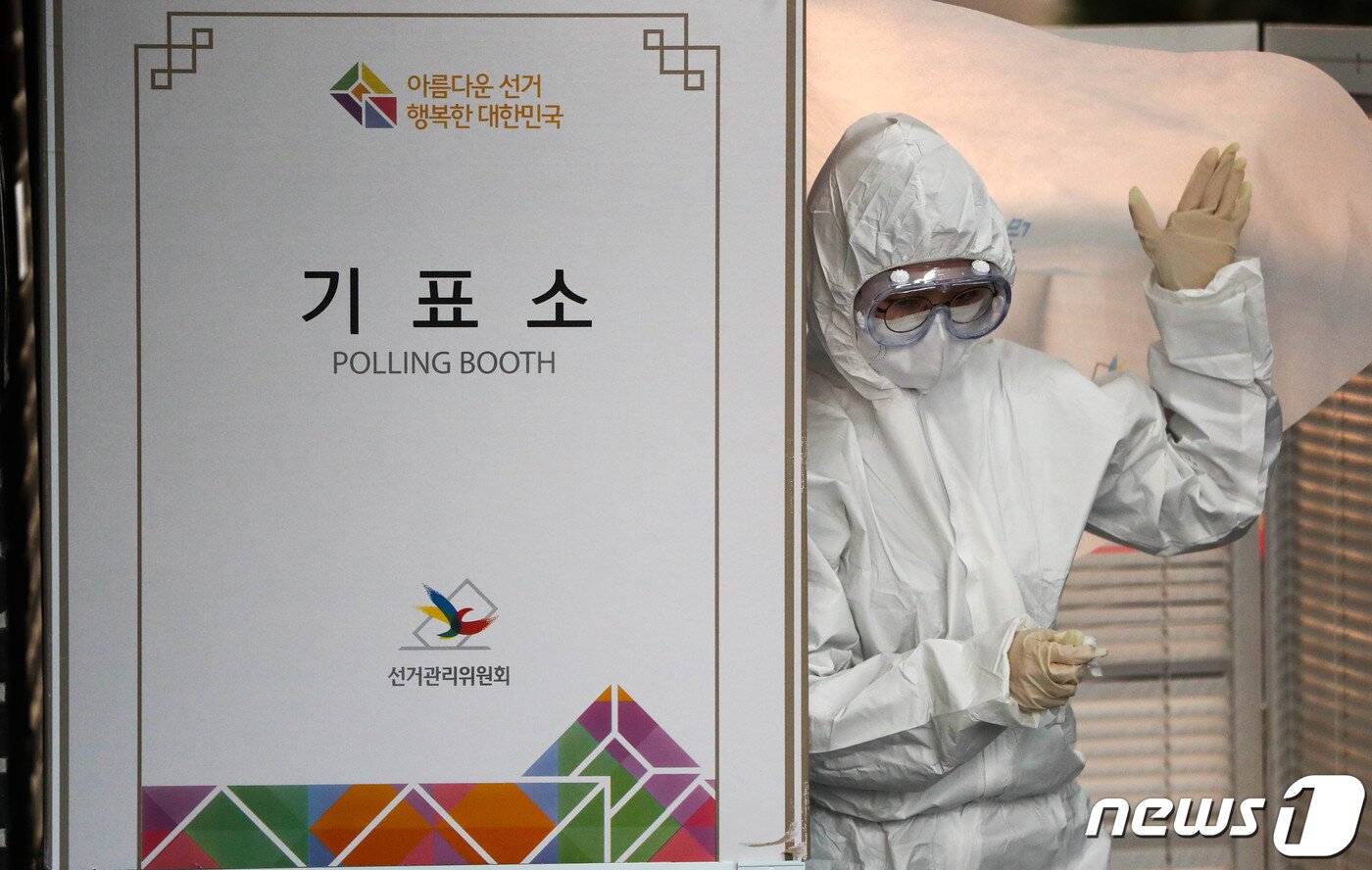 본문 이미지 - 제21대 국회의원 선거 투표일인 15일 서울 가회동 주민센터행정복지센터에 마련된 신종 코로나바이러스 감염증&#40;코로나19&#41; 자가격리자 투표소에서 방호복을 입은 선관위 관계자가 기표소 안을 소독하고 있다. 2020.4.15/뉴스1 ⓒ News1 허경 기자