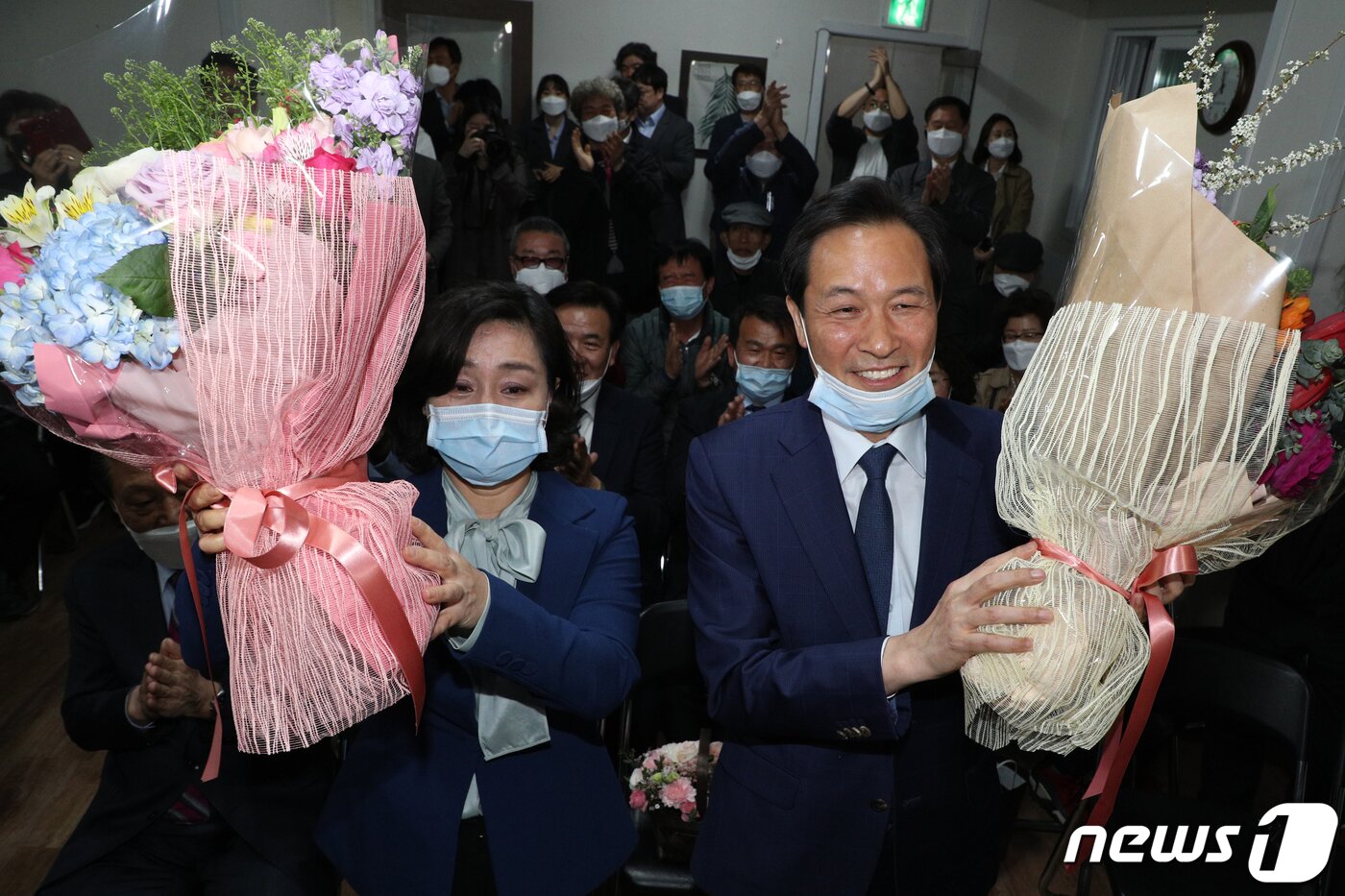 본문 이미지 - 우상호 더불어민주당 서대문갑 후보와 부인 이현주씨가 15일 오후 서울 서대문구 선거사무소 상황실에서 21대 국회의원선거 당선이 유력해지자 꽃다발을 들고 있다. 2020.4.15/뉴스1 ⓒ News1 황기선 기자