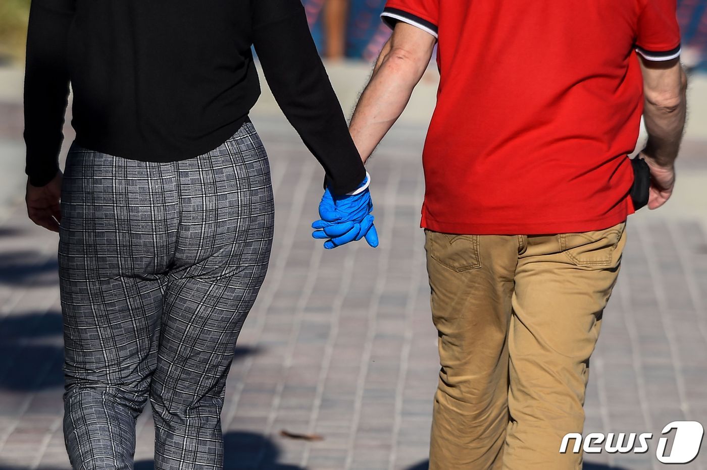 (마이애미 AFP=뉴스1) 우동명 기자 = 1일 (현지시간) 코로나19 확산 속 플로리다주 마이애미의 사우스비치에서 한 커플이 장갑 낀 손을 잡고 있다.ⓒ AFP=뉴스1