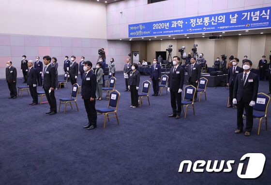 21일 오후 서울 강남구 과학기술회관에서 열린 과학·정보통신의 날 기념식에서 최기영 과학기술정보통신부 장관을 비롯한 참석자들이 사회적 거리를 둔 채 국민의례를 하고 있다. 이번 기념식은 신종 코로나바이러스 감염증(코로나19)으로 인한 사회적 거리 두기의 일환으로 주요 인사와 대표수상자만 참석한 채 온라인 생중계로 진행됐다. 2020.4.21/뉴스1 © News1 신웅수 기자