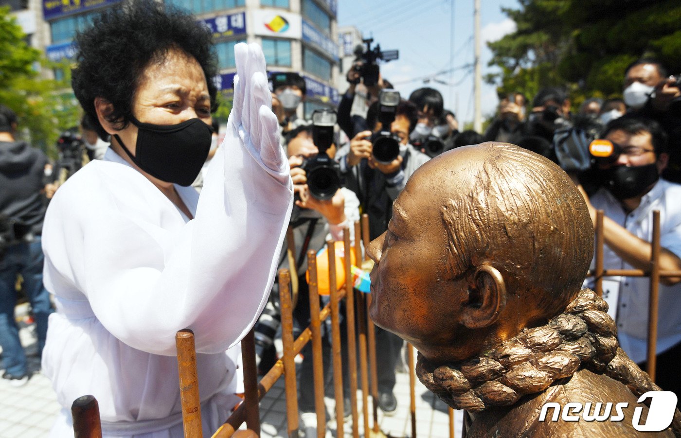 &#39;사자&#40;死者&#41; 명예훼손’ 혐의로 기소된 전두환 씨가 법정에 출석하는 27일 광주 동구 광주지법 앞에서 오월 어머니회 회원이 무릎 꿇은 전두환 동상을 때리고 있다. 2020.4.27/뉴스1 ⓒ News1 황희규 기자