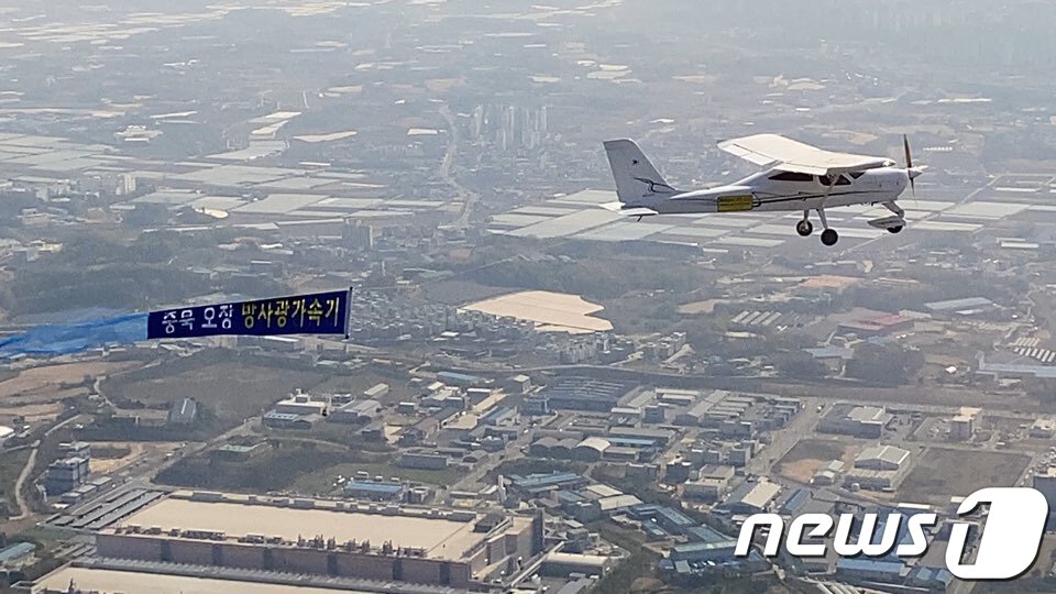 본문 이미지 - 충북테크노파크가 27일 경비행기에 '다목적 방사광가속기 충북 오창 유치' 희망 현수막을 부착하고 비행하는 퍼포먼스를 선보이고 있다. (충북도 제공) 2020.4.27/뉴스1 ⓒ News1 김용빈 기자