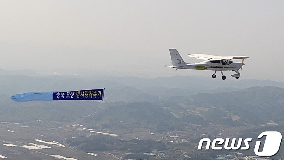 본문 이미지 - 충북테크노파크가 지난달 27일 경비행기에 '다목적 방사광가속기 충북 오창 유치' 희망 현수막을 부착하고 비행하는 퍼포먼스를 선보이고 있다. (충북도 제공) 2020.4.27/뉴스1 ⓒ News1 김용빈 기자