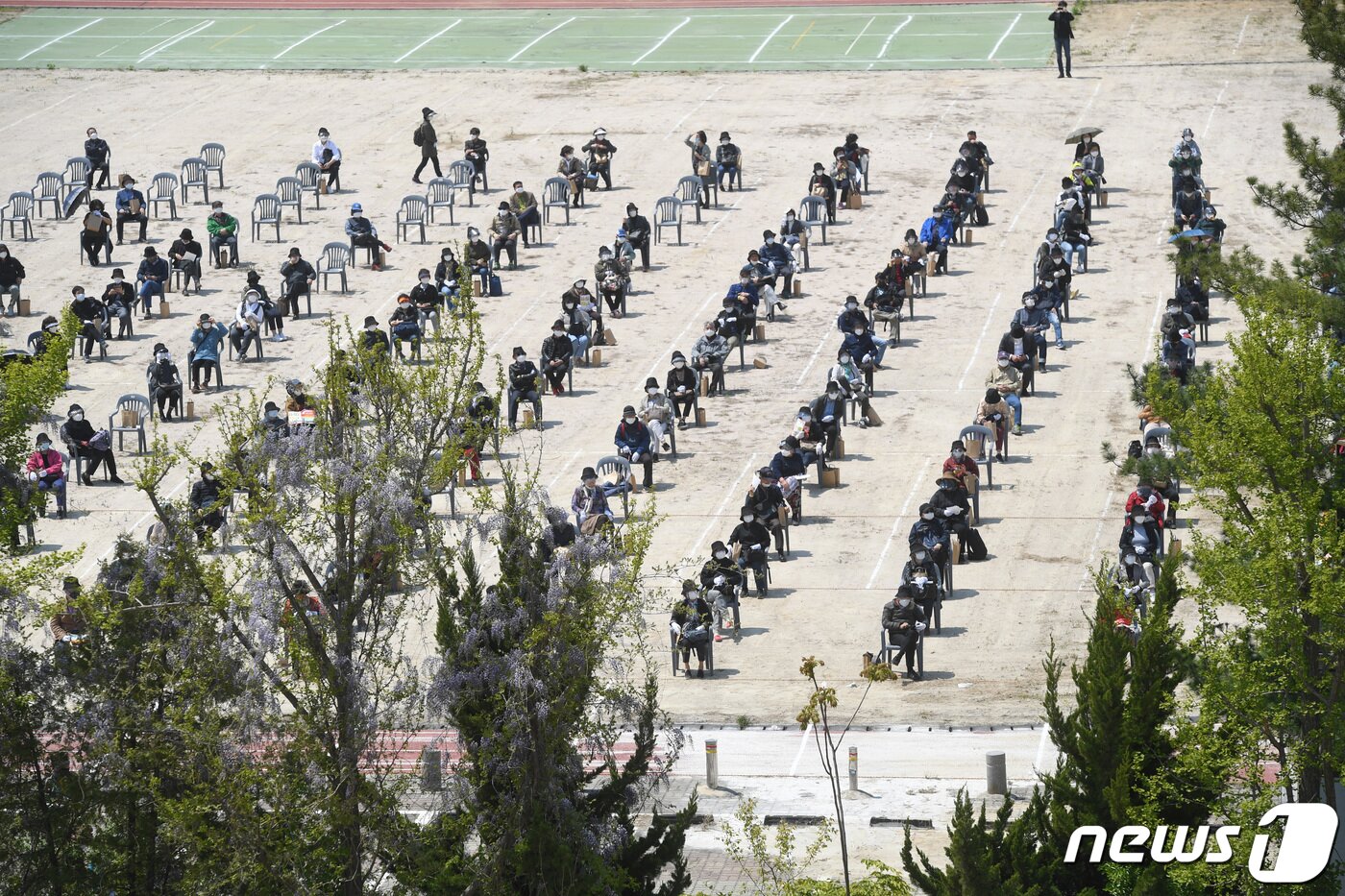 본문 이미지 - 28일 서울 개포주공1단지 내 공터에서 열린 재건축 조합의 ‘드라이브 스루’ 관리처분 총회에서 차량 이용이 불가능한 조합원들이 폐교 운동장에 거리를 두며 의자에 앉아 총회 안건을 듣고 있다. ⓒ News1 박지혜 기자