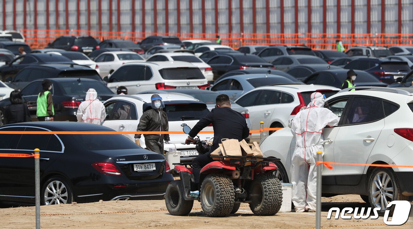 본문 이미지 - 28일 서울 개포주공1단지 내 공터에서 열린 재건축 조합의 ‘드라이브 스루’ 관리처분 총회에서 4륜구동 바이크를 탄 직원이 조합원들의 차량에서 수거된 투표용지를 옮기고 있다. ⓒ News1 박지혜 기자