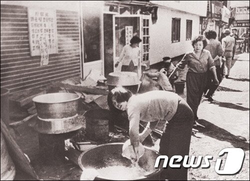 본문 이미지 - 80년 5월 민주화운동 기간 길가에 솥을 걸고 밥을 하는 아주머니들. 시민군과 항쟁 지도부의 끼니는 시민들이 자발적으로 지어다 준 밥으로 해결됐다.(5.18기념재단 제공) /ⓒ 뉴스1
