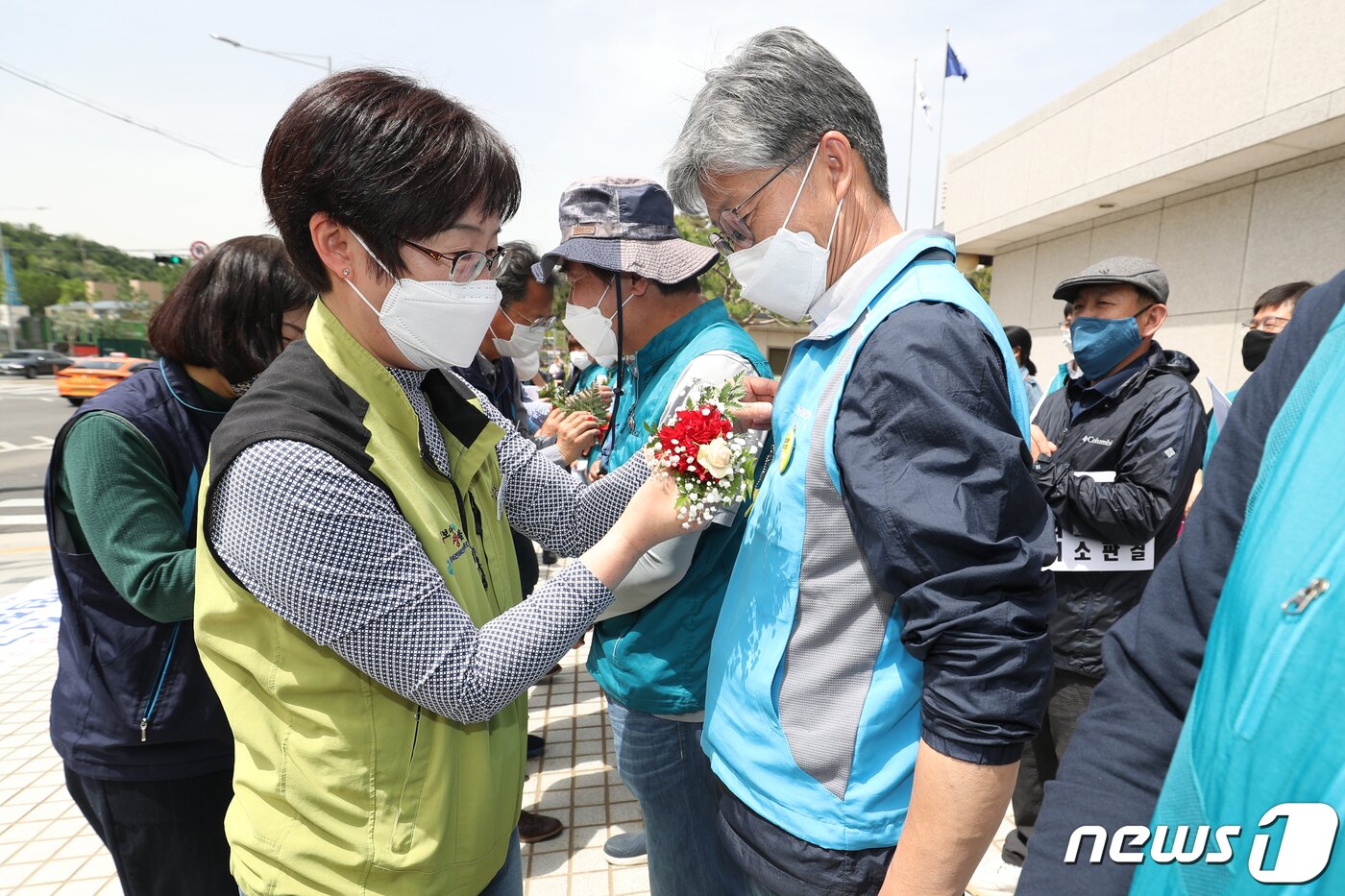 본문 이미지 - 민주노총과 전교조 조합원들이 14일 오전 서울 서초구 대법원 앞에서 열린 '전교조 법외노조 취소판결 촉구 기자회견'에서 해직교사들에게 카네이션을 달아주고 있다. 이날 참가자들은 "부당하게 해직된 교사노동자들을 복직시키고 전교조를 합법화하여 헌법에 보장된 노동3권 및 기본권리를 보장받도록 원상회복해야한다＂고 주장했다. 2020.5.14/뉴스1 ⓒ News1 민경석 기자