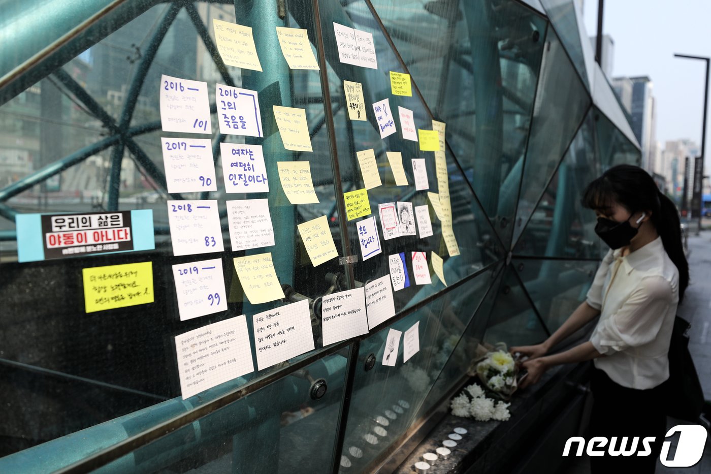 본문 이미지 - 강남역 여성 살인사건 4주기를 맞은 17일 오후 서울 강남역 10번 출구 앞에서 한 시민이 피해자를 추모하며 꽃을 놓고 있다. 2020.5.17/뉴스1 ⓒ News1 이승배 기자