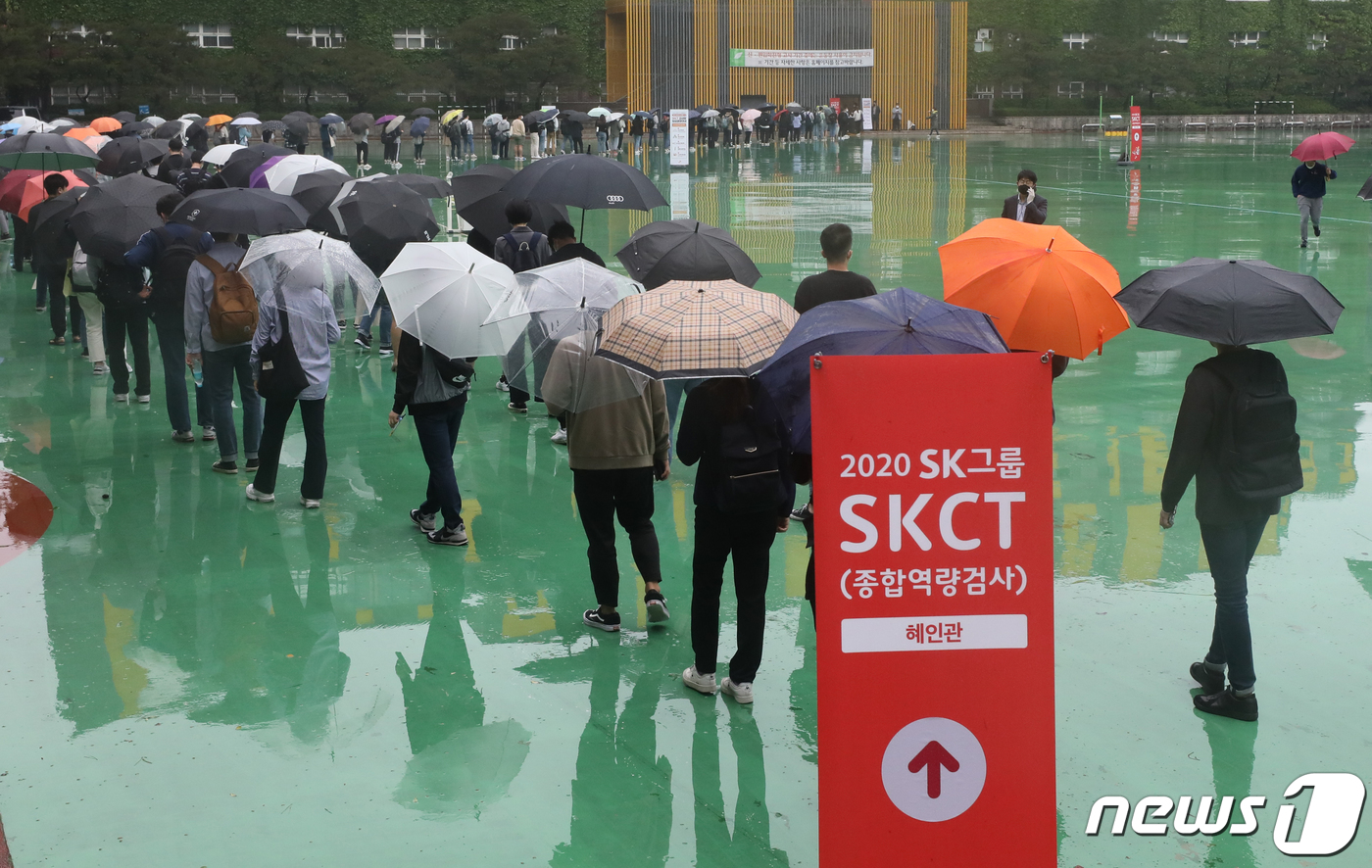 (서울=뉴스1) 송원영 기자 = 24일 서울 성북구 서경대학교에서 열린 SK 그룹 상반기 공채 필기전형인 SK종합역량검사(SKCT)에서 우산을 쓴 수험생들이 거리를 두고 시험에 참 …