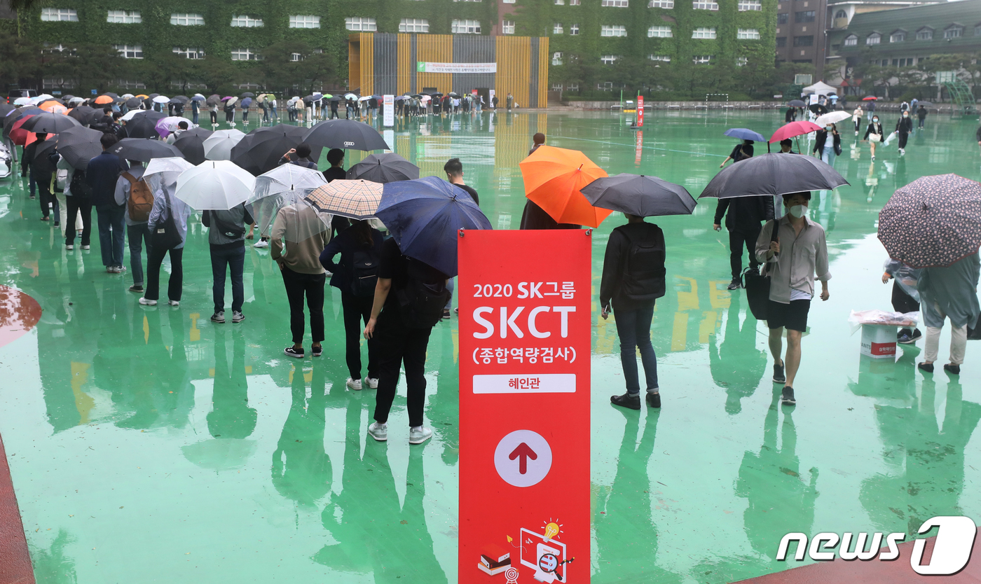 (서울=뉴스1) 송원영 기자 = 24일 서울 성북구 서경대학교에서 열린 SK 그룹 상반기 공채 필기전형인 SK종합역량검사(SKCT)에서 우산을 쓴 수험생들이 거리를 두고 시험에 참 …