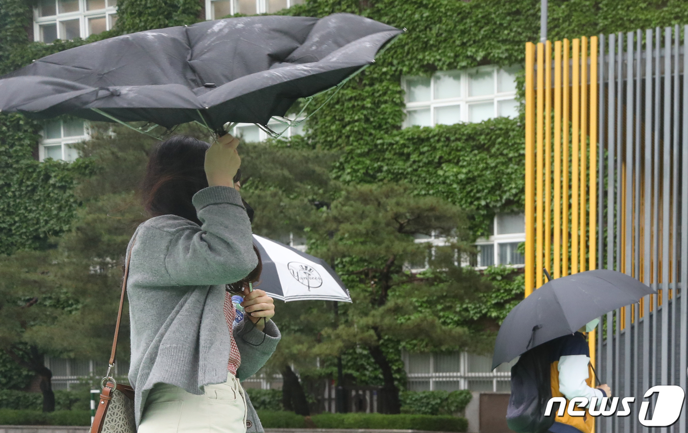 (서울=뉴스1) 송원영 기자 = 24일 서울 성북구 서경대학교에서 열린 SK 그룹 상반기 공채 필기전형인 SK종합역량검사(SKCT)에서 비바람에 뒤집어진 우산을 쓴 수험생들이 시험 …