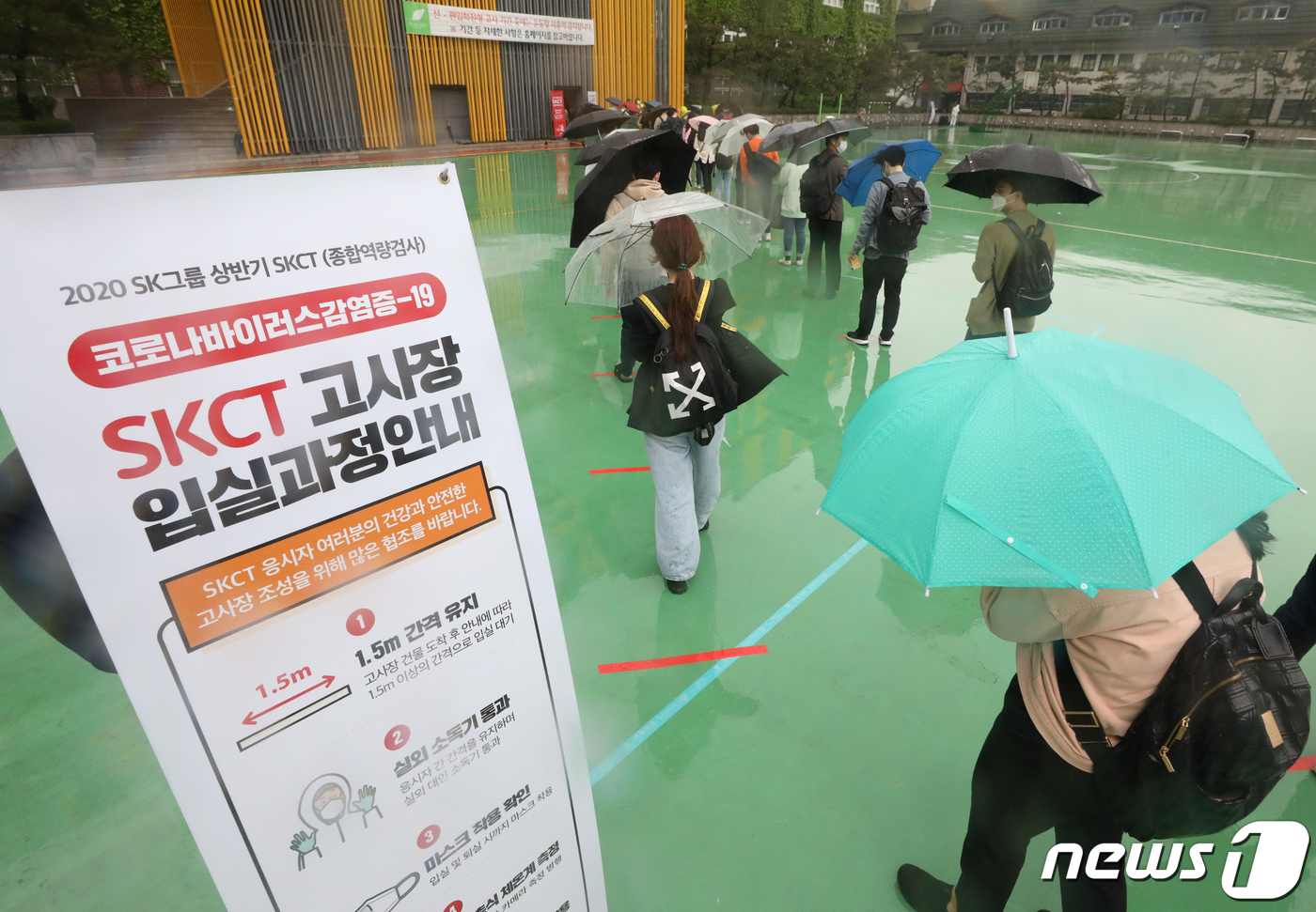 (서울=뉴스1) 송원영 기자 = 24일 서울 성북구 서경대학교에서 열린 SK 그룹 상반기 공채 필기전형인 SK종합역량검사(SKCT)에서 우산을 쓴 수험생들이 거리를 두고 시험에 참 …