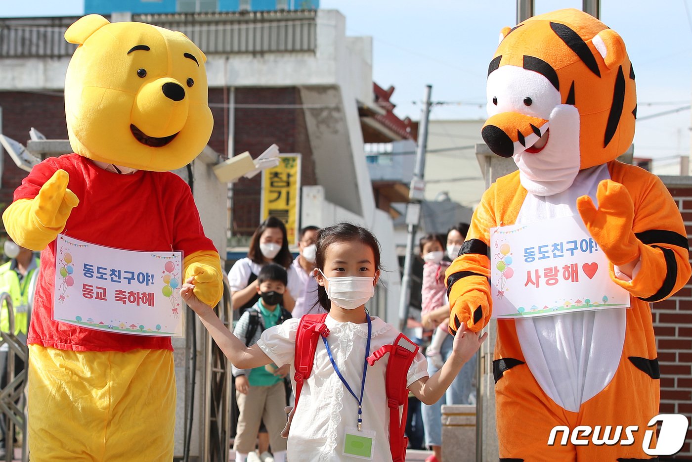 27일 오전 대구 수성구 범어동 대구동도초등학교 정문에서 애니메이션 캐릭터 곰돌이 푸와 티거 인형탈을 쓴 서정하 학교장과 김수완 상담교사가 신종 코로나바이러스 감염증&#40;코로나19&#41; 확산 여파로 온라인 입학 후 87일만에 처음으로 등교하는 1학년 신입생들을 반갑게 맞이하고 있다. 2020.5.27/뉴스1 ⓒ News1 공정식 기자