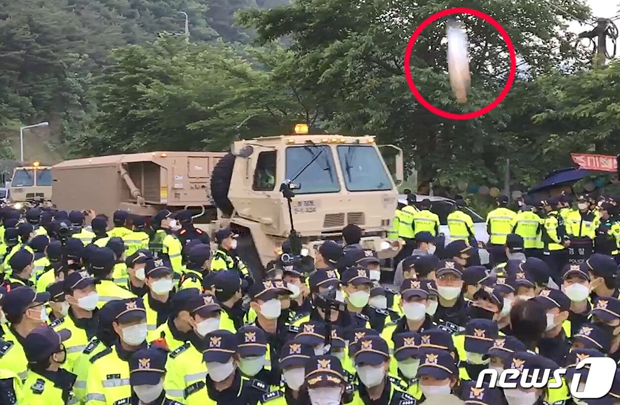 본문 이미지 - 29일 오전 경북 성주군 초전면 소성리에 경찰병력이 배치된 가운데 군 장비를 싣고 주한미군 사드(THAAD·고고도미사일방어체계) 기지를 향해 이동하는 트럭에 생수통이 날아들고 있다. 국방부는 이날 성주 사드 기지의 노후장비 교체를 위한 지상수송을 지원했다고 밝혔다. (소성리 종합상황실 제공) 2020.5.29/뉴스1 ⓒ News1 공정식 기자