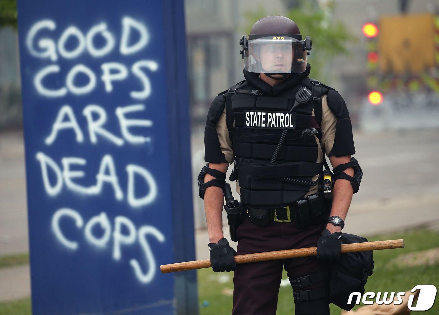 본문 이미지 - 29일(현지시간) 미국 미네소타주 미니애폴리스 시위 현장에 투입된 주방위군 뒤로 '좋은 경찰은 죽은 경찰'이라고 경찰을 조롱하는 문구가 적혀 있다. ⓒ AFP=뉴스1