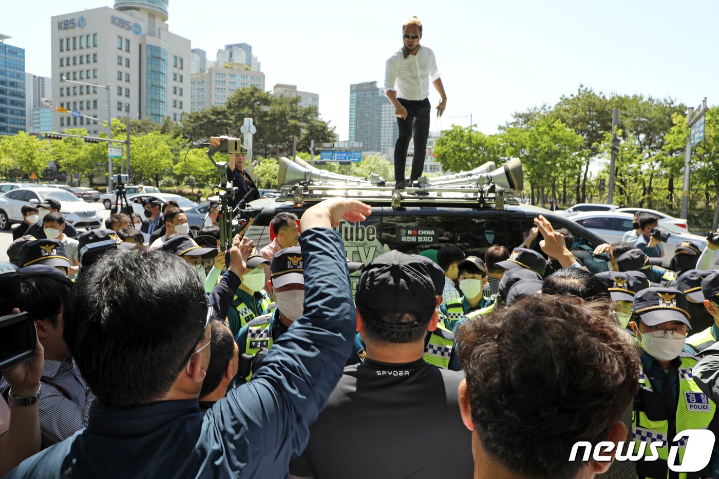 본문 이미지 - 광주시청 인근 사거리에서 한 보수 성향 유튜버가 차량 위에 올라가 &#34;가짜 5·18유공자가 있다&#34;며 오월 단체 회원들을 도발하고 있다.2020.5.6/뉴스1 ⓒ News1 허단비 기자